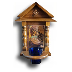 Dřevěný ikonostas s ikonou Panny Marie a skleněným pohárem na svíčku